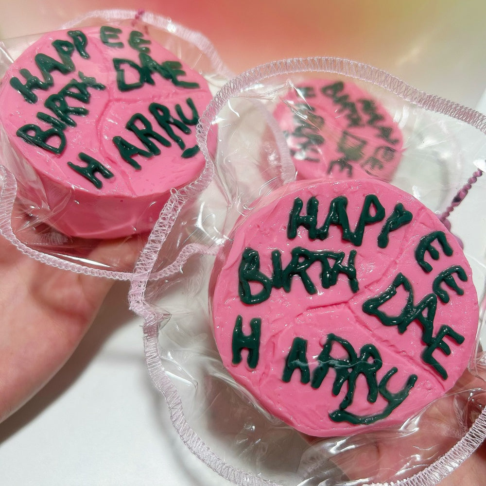Happee Birthdae Cake squishy toy being squeezed, showing slow-rebound texture