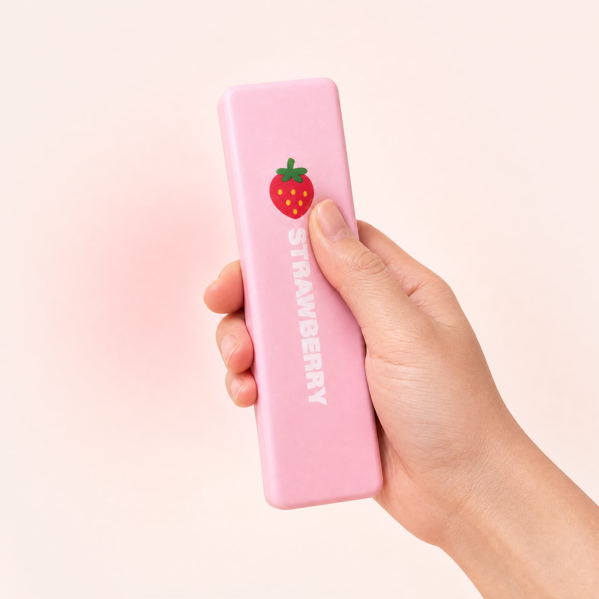 Slow Rise Butter Sticks squishy toy, strawberry cream flavor, held in one hand being squeezed